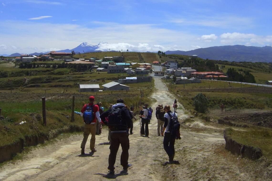 Hikers walking along a rural road on the Quilotoa Loop in the Ecuadorian Andes.