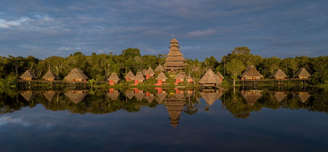 Panoramic view of Napo Wildlife Center eco-lodge nestled in the heart of Yasuni National Park, surrounded by lush Amazon rainforest and a serene blackwater lagoon.