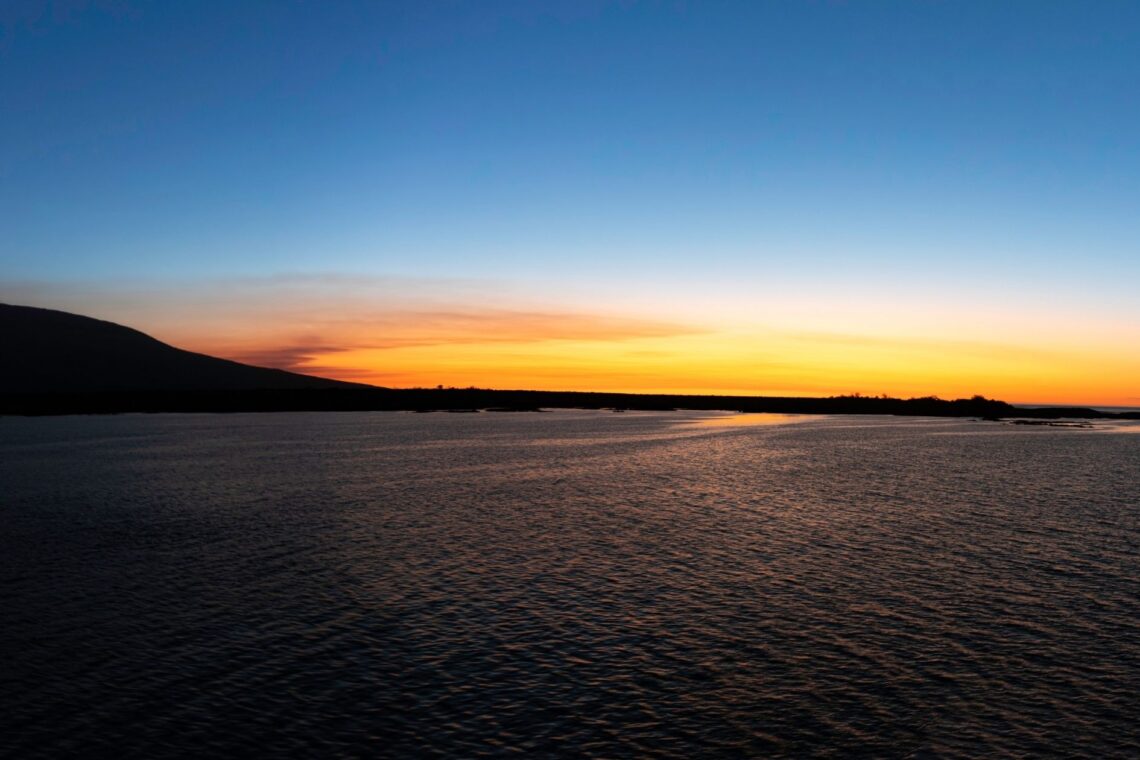 Golden sunset over Fernandina Island, the youngest and most volcanically active island in the Galápagos. Lava flows meet the Pacific Ocean, creating a dramatic landscape untouched by human presence — a sanctuary for marine iguanas, flightless cormorants, and Galápagos hawks.